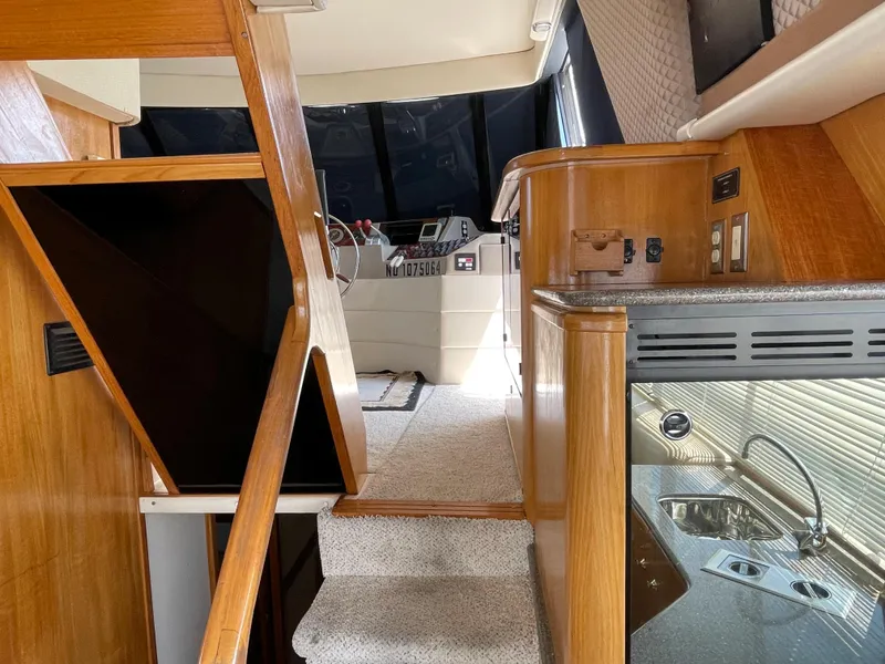 Slide: The Image of 1998 Bayliner 4788 Pilot House Motoryacht interior with stairs, helm, and kitchenette. - 40