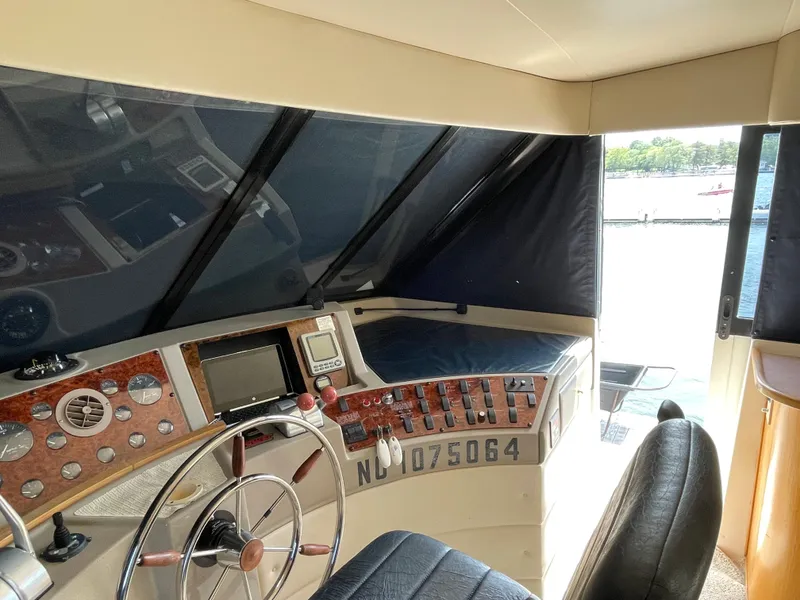 Slide: The Image of 1998 Bayliner 4788 Pilot House Motoryacht helm station with navigation controls and steering wheel. - 43