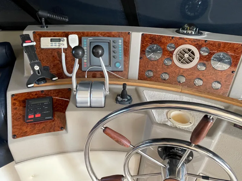 Slide: The Image of 1998 Bayliner 4788 Pilot House Motoryacht helm with navigation controls and steering wheel. - 44