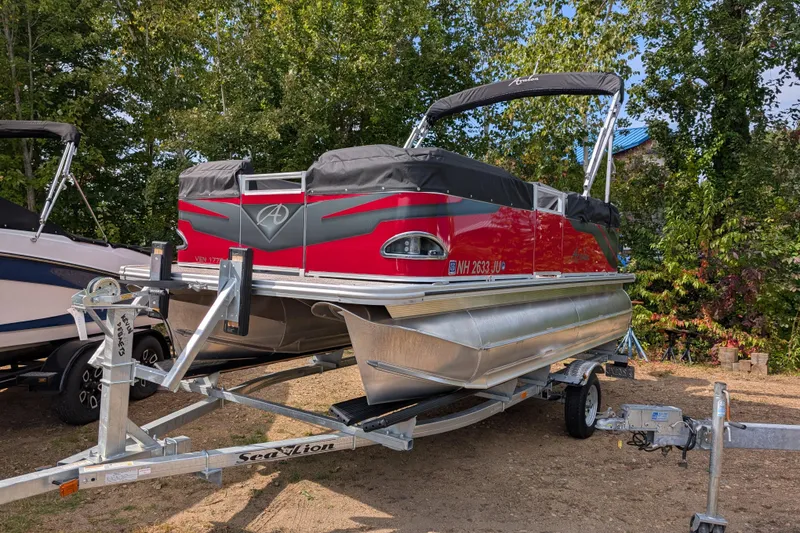 Slide: The Image of 2023 Avalon VENTURE CRUISE pontoon boat on trailer, surrounded by trees. - 0