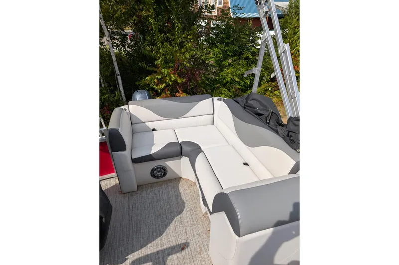 Slide: The Image of 2023 Avalon VENTURE CRUISE boat interior with gray and white seating, surrounded by greenery. - 6