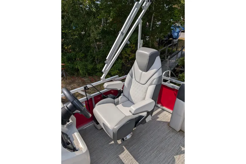 Slide: The Image of 2023 Avalon VENTURE CRUISE boat seat with steering wheel, surrounded by greenery. - 8