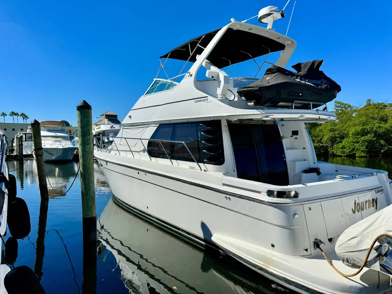 The Image of 1999 Carver 450 Pilothouse yacht docked in a marina. - 0