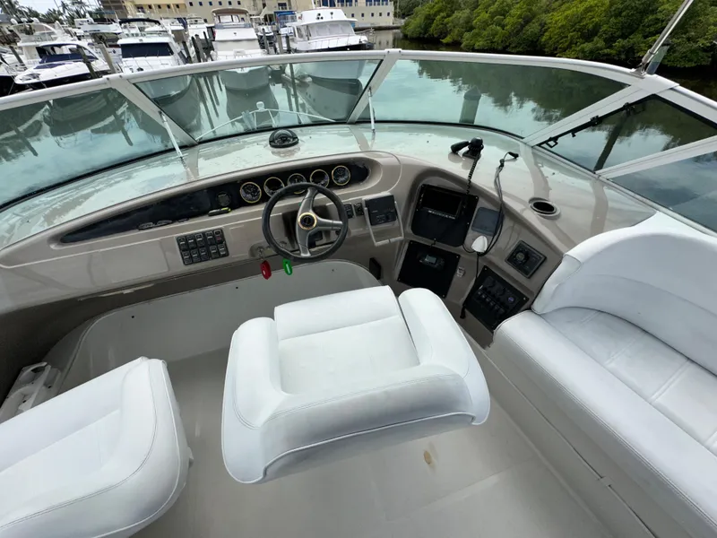 Slide: The Image of 1999 Carver 450 Pilothouse yacht helm with white seating and control panel. - 13