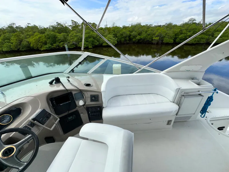 Slide: The Image of 1999 Carver 450 Pilothouse boat interior with white seating and control panel. - 14