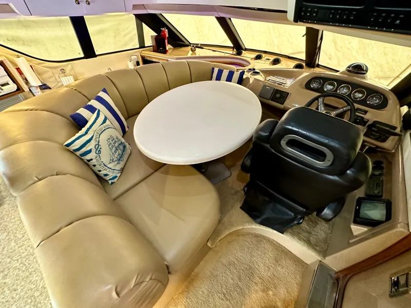Slide: The Image of 1999 Carver 450 Pilothouse interior with beige seating, round table, and captain's chair. - 29