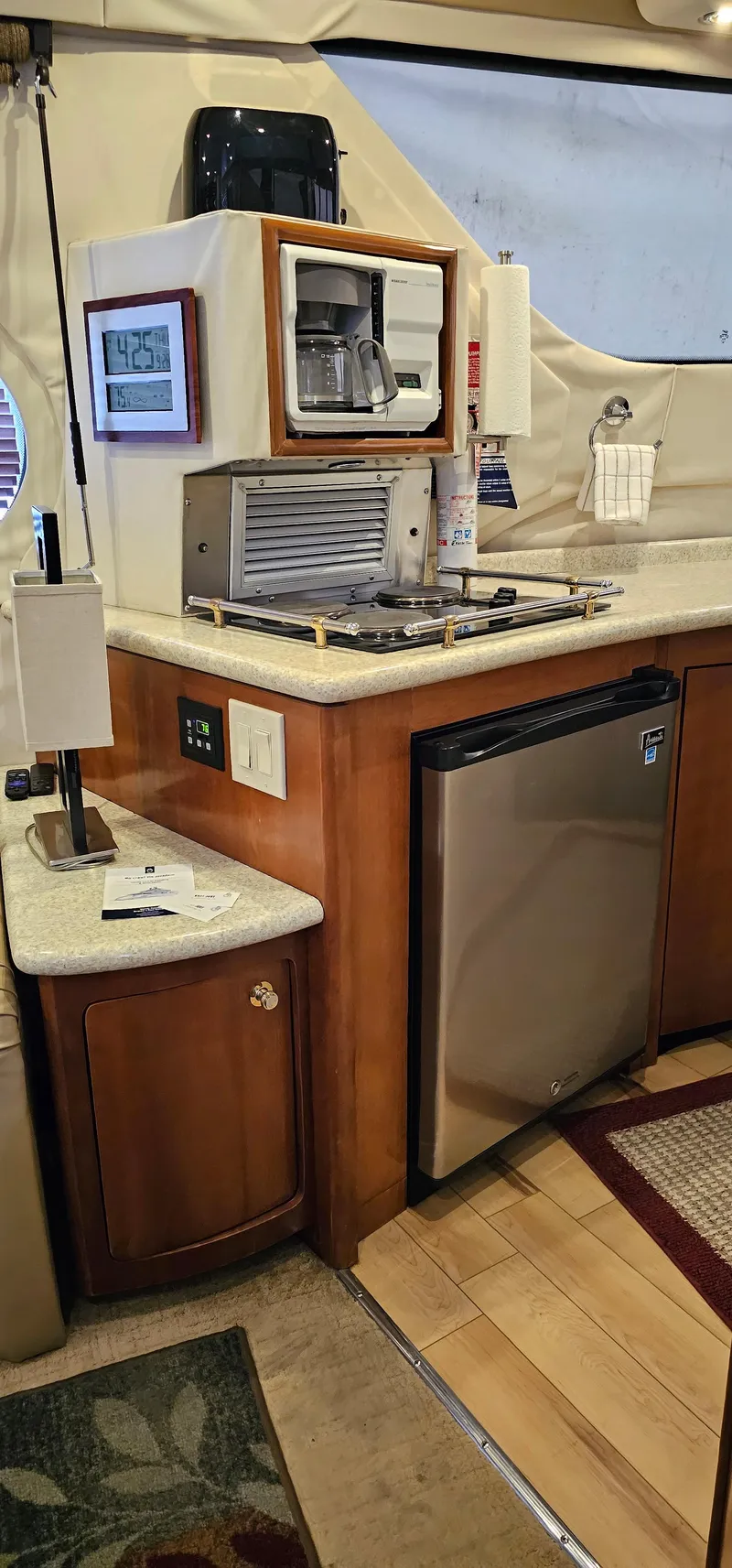 Slide: The Image of 1999 Carver 450 Pilothouse yacht kitchen with mini fridge, microwave, and countertop appliances. - 35