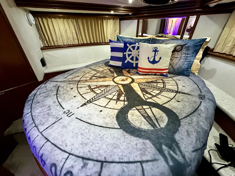 Slide: The Image of Nautical-themed bedroom in a 1999 Carver 450 Pilothouse yacht with compass bedding and decorative pillows. - 40