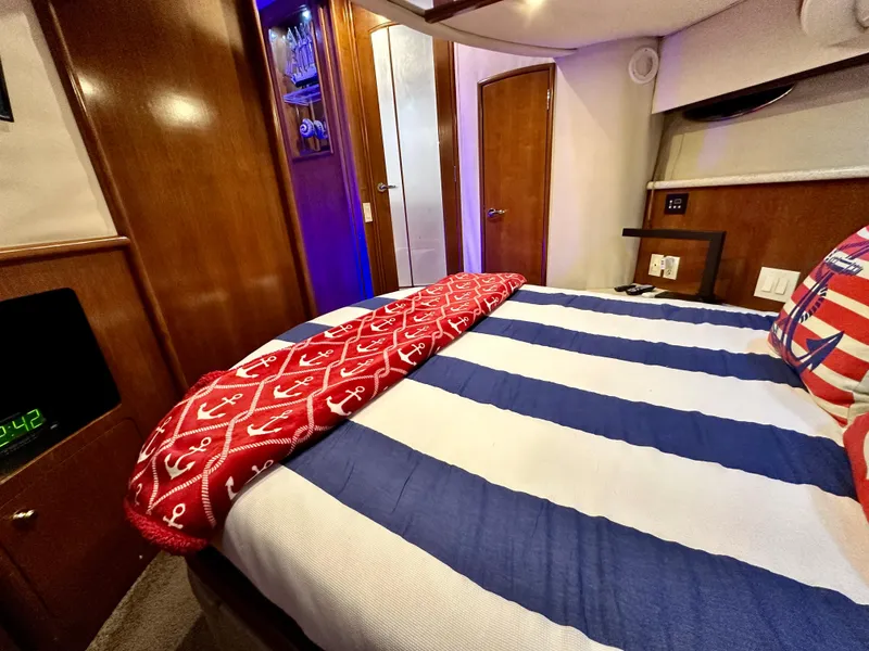 Slide: The Image of 1999 Carver 450 Pilothouse bedroom with nautical-themed bedding. - 44