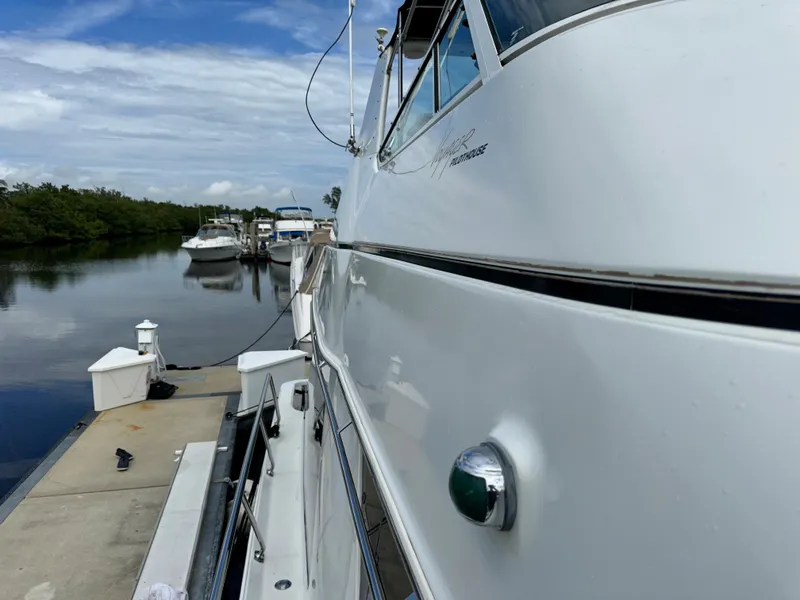 Slide: The Image of 1999 Carver 450 Pilothouse yacht docked at a marina on a sunny day. - 6