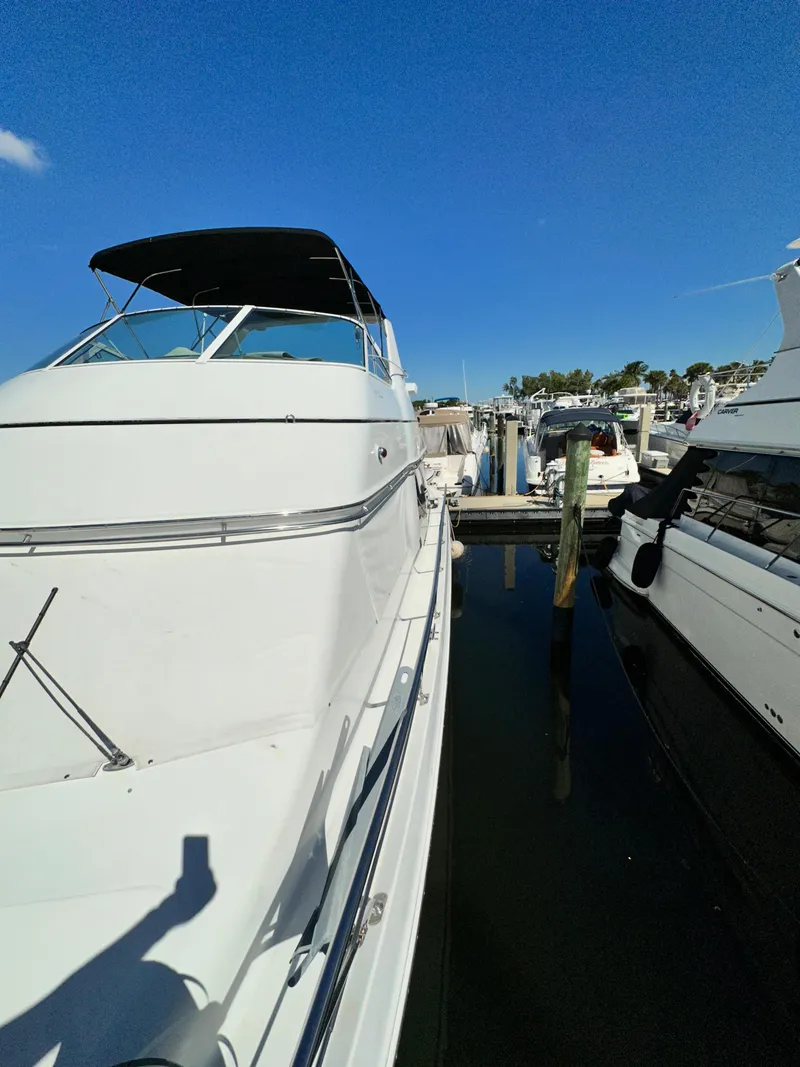Slide: The Image of 1999 Carver 450 Pilothouse yacht docked at a marina on a sunny day. - 9