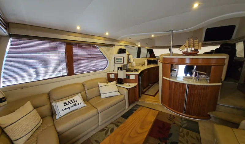 Slide: The Image of 1999 Carver 450 Pilothouse interior with cozy seating and modern amenities. - 24