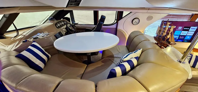Slide: The Image of Interior of 1999 Carver 450 Pilothouse with leather seating, round table, and nautical decor. - 31