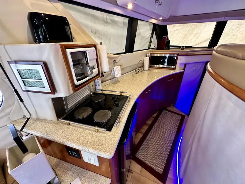 Slide: The Image of 1999 Carver 450 Pilothouse yacht kitchen with modern appliances and curved countertops. - 33