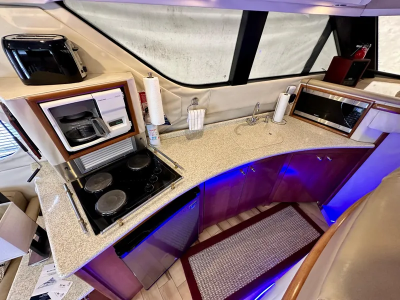 Slide: The Image of Carver 450 Pilothouse 1999 yacht kitchen with stove, microwave, and coffee maker. - 34
