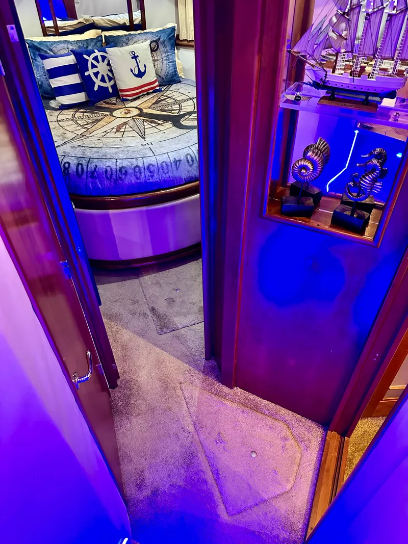 Slide: The Image of 1999 Carver 450 Pilothouse interior with nautical-themed bedroom and blue lighting. - 38