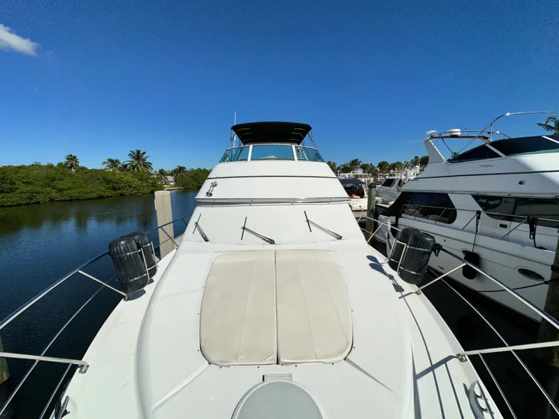 Slide: The Image of 1999 Carver 450 Pilothouse yacht docked in a marina under clear blue sky. - 4