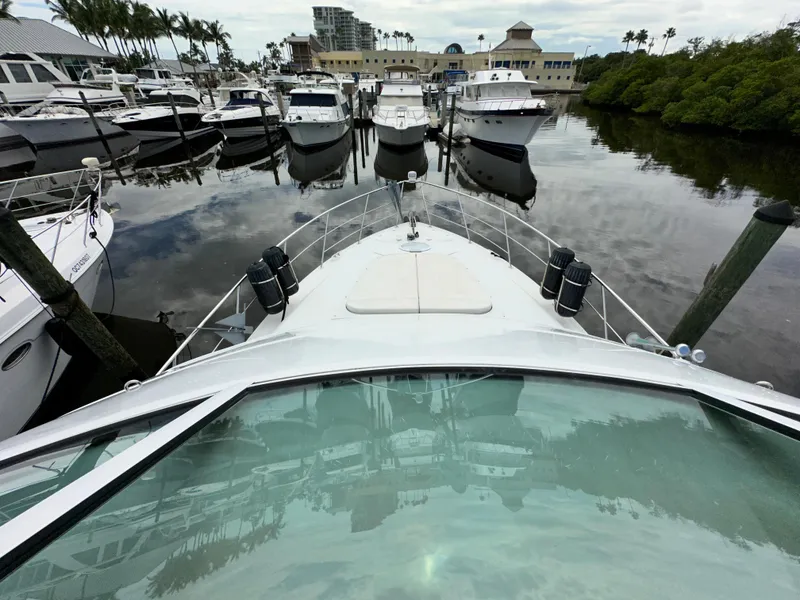 Slide: The Image of 1999 Carver 450 Pilothouse yacht docked at a marina with other boats. - 7