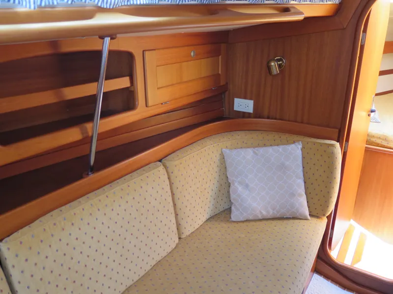 Slide: The Image of Interior of 2002 Arcona 355 Sloop with cushioned seating and wooden cabinetry. - 10
