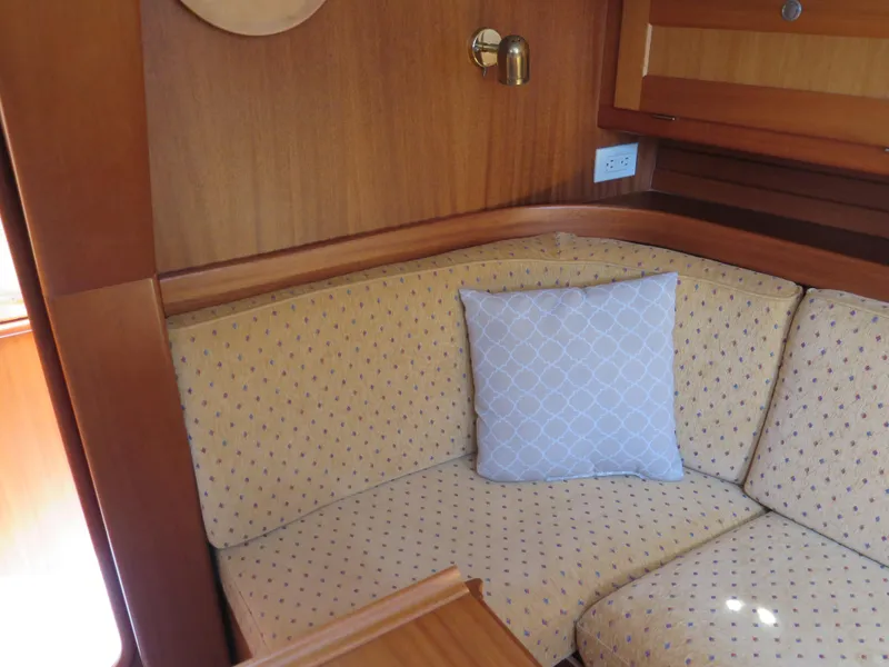 Slide: The Image of 2002 Arcona 355 Sloop interior with cushioned seating and decorative pillow. - 12