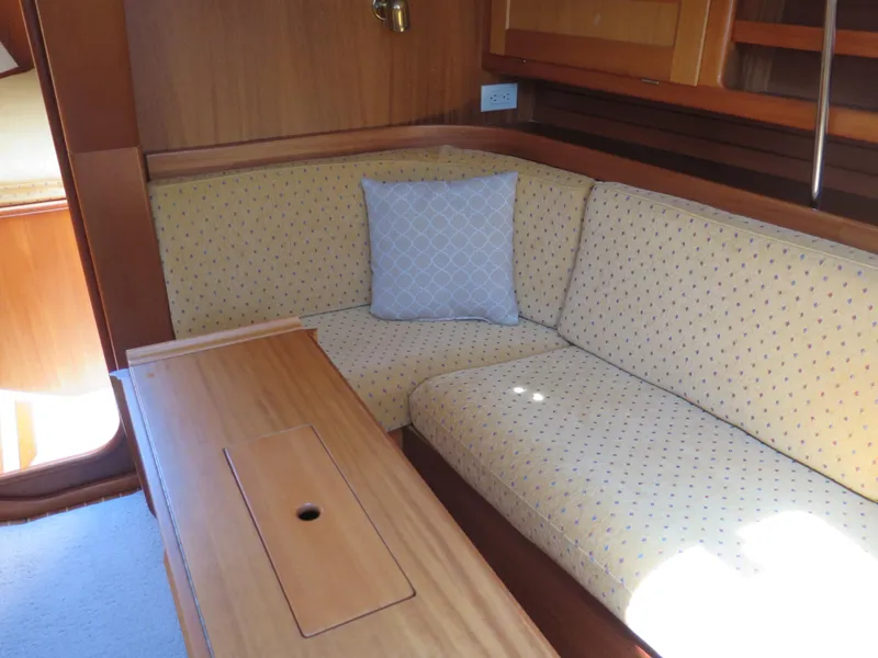 Slide: The Image of Interior of 2002 Arcona 355 Sloop with cushioned seating and wooden table. - 13