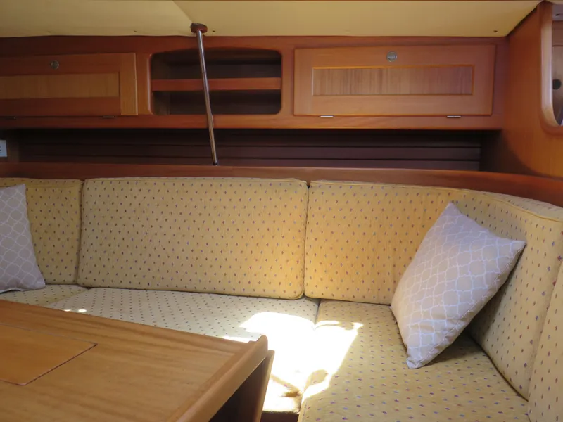 Slide: The Image of Interior seating area of a 2002 Arcona 355 Sloop with cushioned benches and wooden cabinetry. - 14