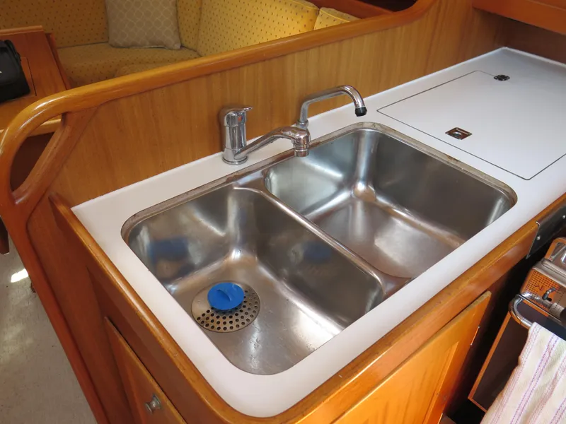 Slide: The Image of 2002 Arcona 355 Sloop kitchen sink with double stainless steel basins and wooden cabinetry. - 19