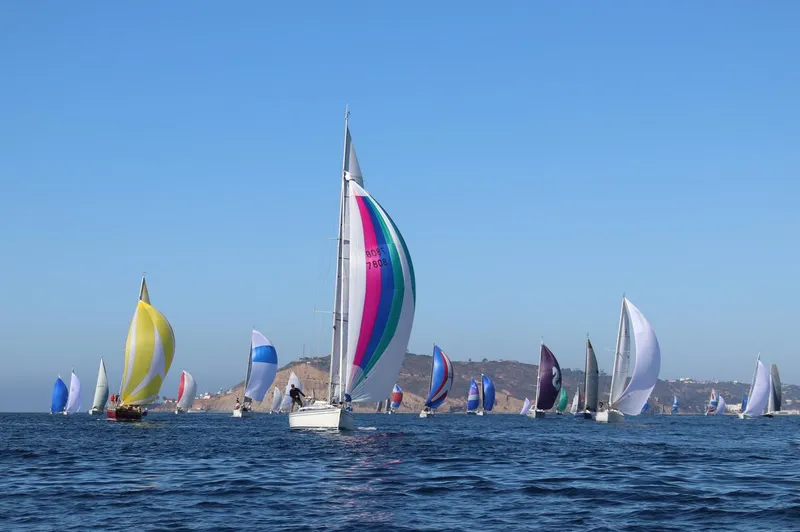Slide: The Image of Sailboats racing on open water, featuring a 2002 Arcona 355 Sloop. - 2