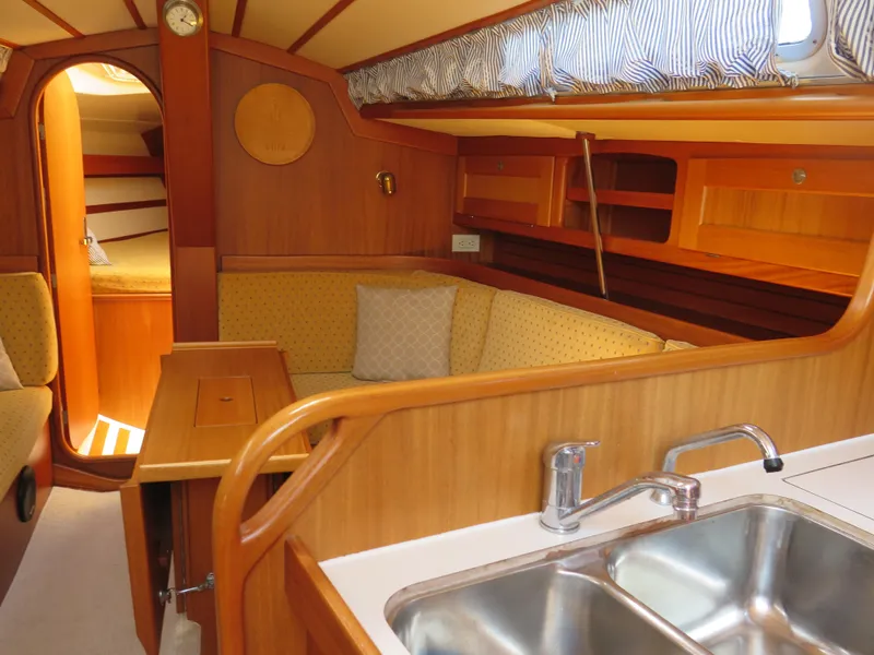 Slide: The Image of Interior of 2002 Arcona 355 Sloop with wooden finish, seating area, and kitchen sink. - 20