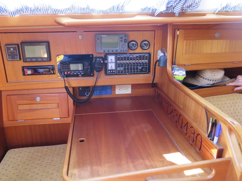 Slide: The Image of Navigation station of a 2002 Arcona 355 Sloop with control panels and communication equipment. - 24
