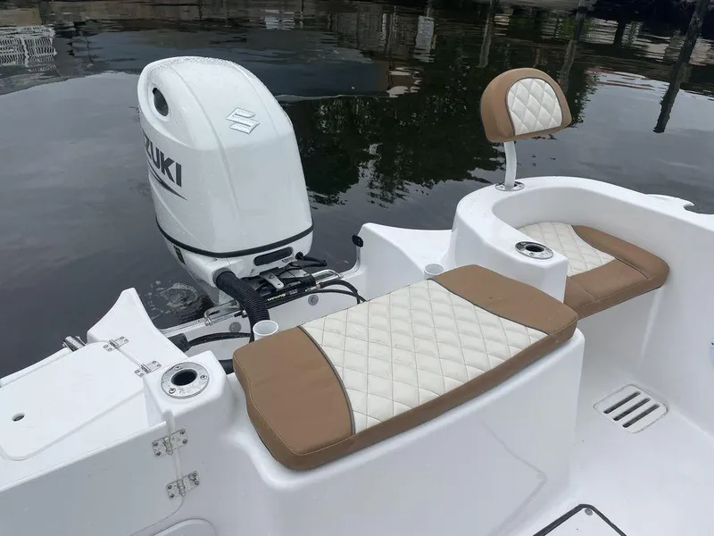 Slide: The Image of 2024 Polar 220 CC boat with Suzuki outboard motor and tan cushioned seating. - 13
