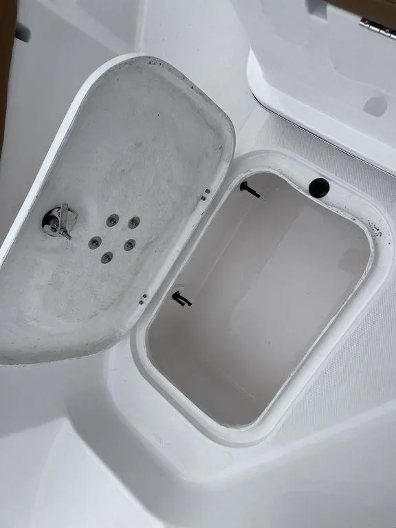 Slide: The Image of 2024 Polar 220 CC boat storage compartment with open lid. - 15