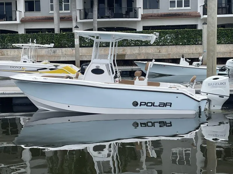 Slide: The Image of 2024 Polar 220 CC boat docked, side view with Suzuki outboard motor. - 3