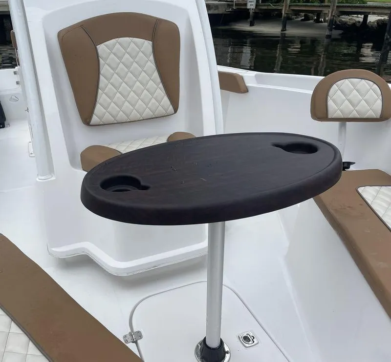 Slide: The Image of 2024 Polar 220 CC boat interior with cushioned seating and a central table. - 6