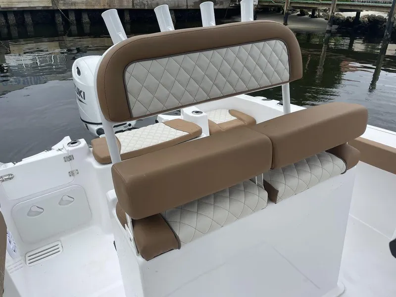 Slide: The Image of 2024 Polar 220 CC boat with tan and white seating, docked by the water. - 7