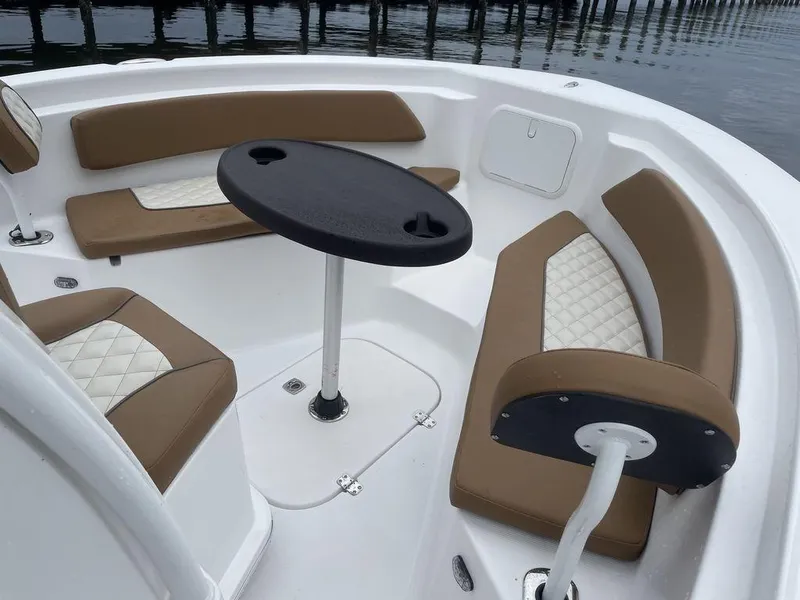 Slide: The Image of 2024 Polar 220 CC boat interior with cushioned seating and table. - 8