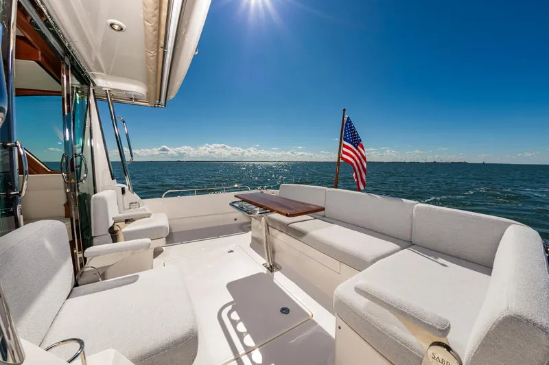 Slide: The Image of 2024 Sabre 43 Salon Express yacht deck with ocean view and American flag. - 13