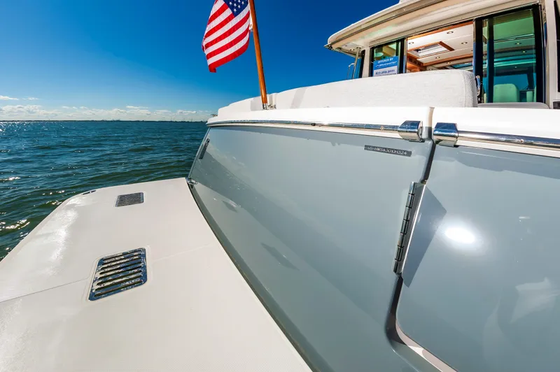 Slide: The Image of 2024 Sabre 43 Salon Express yacht on open water with American flag. - 17