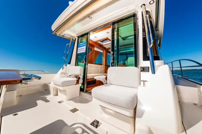 Slide: The Image of 2024 Sabre 43 Salon Express yacht with luxurious seating and glass doors. - 18