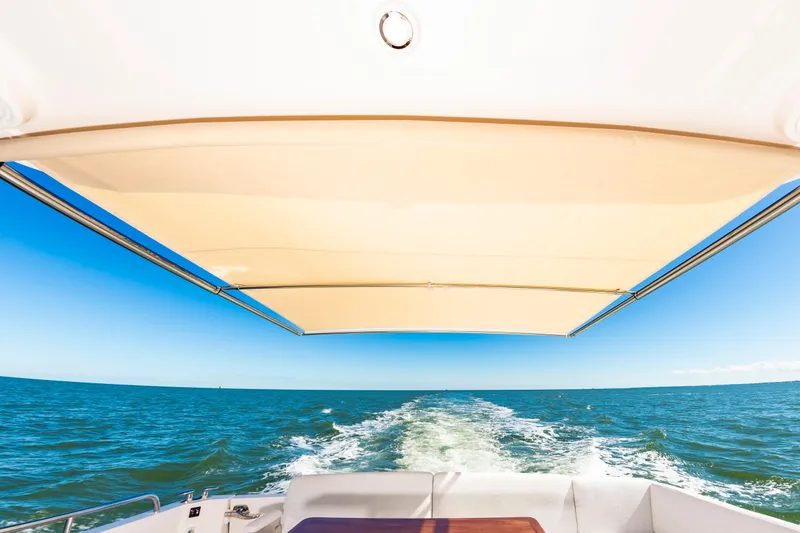 Slide: The Image of View from the 2024 Sabre 43 Salon Express boat, featuring a sunshade and ocean wake. - 19