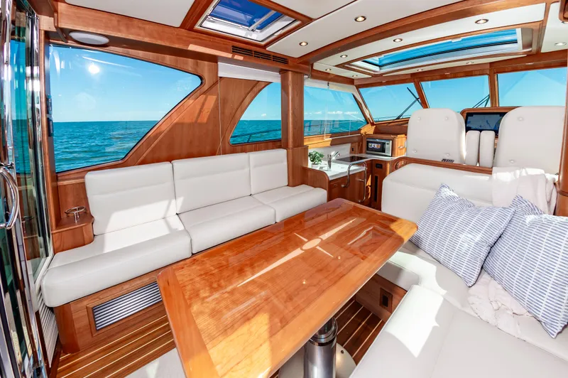 Slide: The Image of Interior of 2024 Sabre 43 Salon Express yacht with ocean view, white seating, and wooden table. - 20