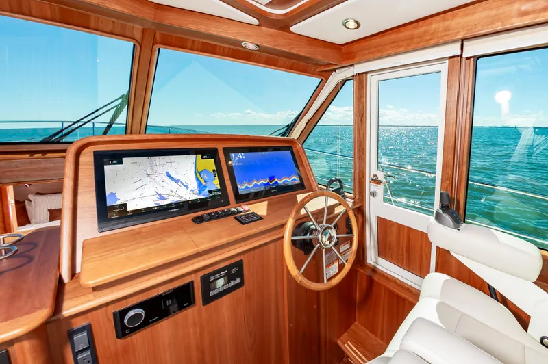 Slide: The Image of Interior helm of 2024 Sabre 43 Salon Express yacht with navigation screens and ocean view. - 28