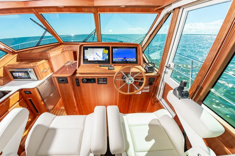 Slide: The Image of Interior helm of 2024 Sabre 43 Salon Express yacht with navigation screens and wooden finish. - 30