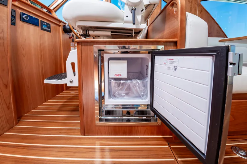 Slide: The Image of 2024 Sabre 43 Salon Express interior with open mini fridge and wooden flooring. - 35