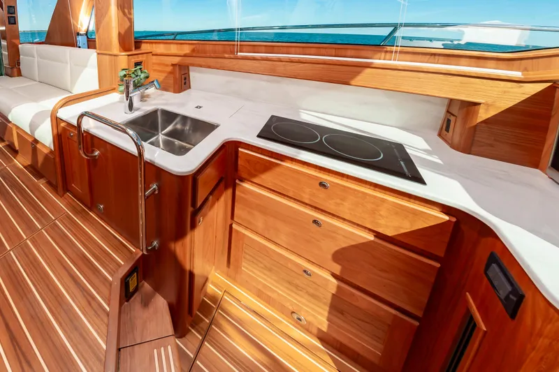 Slide: The Image of 2024 Sabre 43 Salon Express yacht interior kitchen with wooden cabinetry and ocean view. - 41