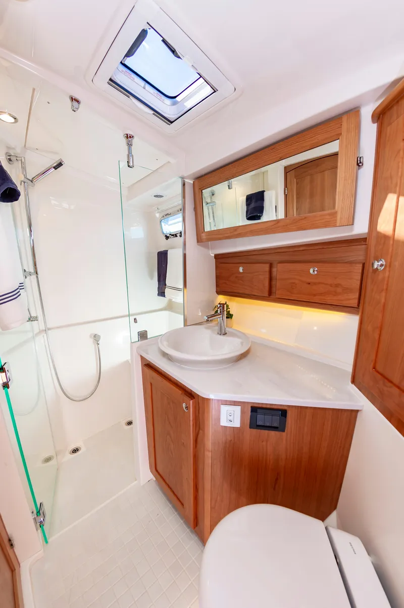 Slide: The Image of 2024 Sabre 43 Salon Express bathroom with modern fixtures and wooden cabinetry. - 48