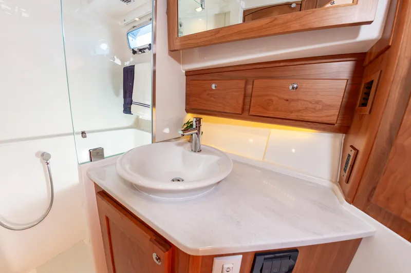 Slide: The Image of 2024 Sabre 43 Salon Express bathroom with wooden cabinetry and modern sink. - 49