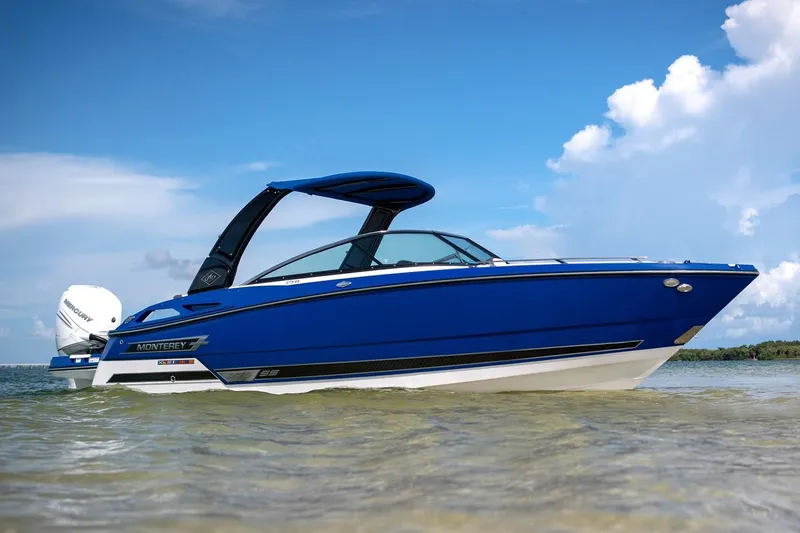 Slide: The Image of 2024 Monterey 275 Super Sport boat in blue on clear water with a cloudy sky. - 17