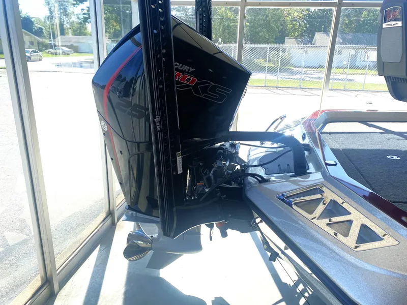 Slide: The Image of 2021 Ranger Z521L boat with powerful outboard motor in a sunlit showroom. - 13