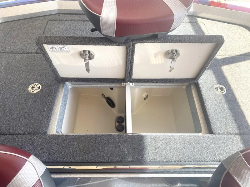 Slide: The Image of 2021 Ranger Z521L boat storage compartments with open lids and maroon seats. - 21